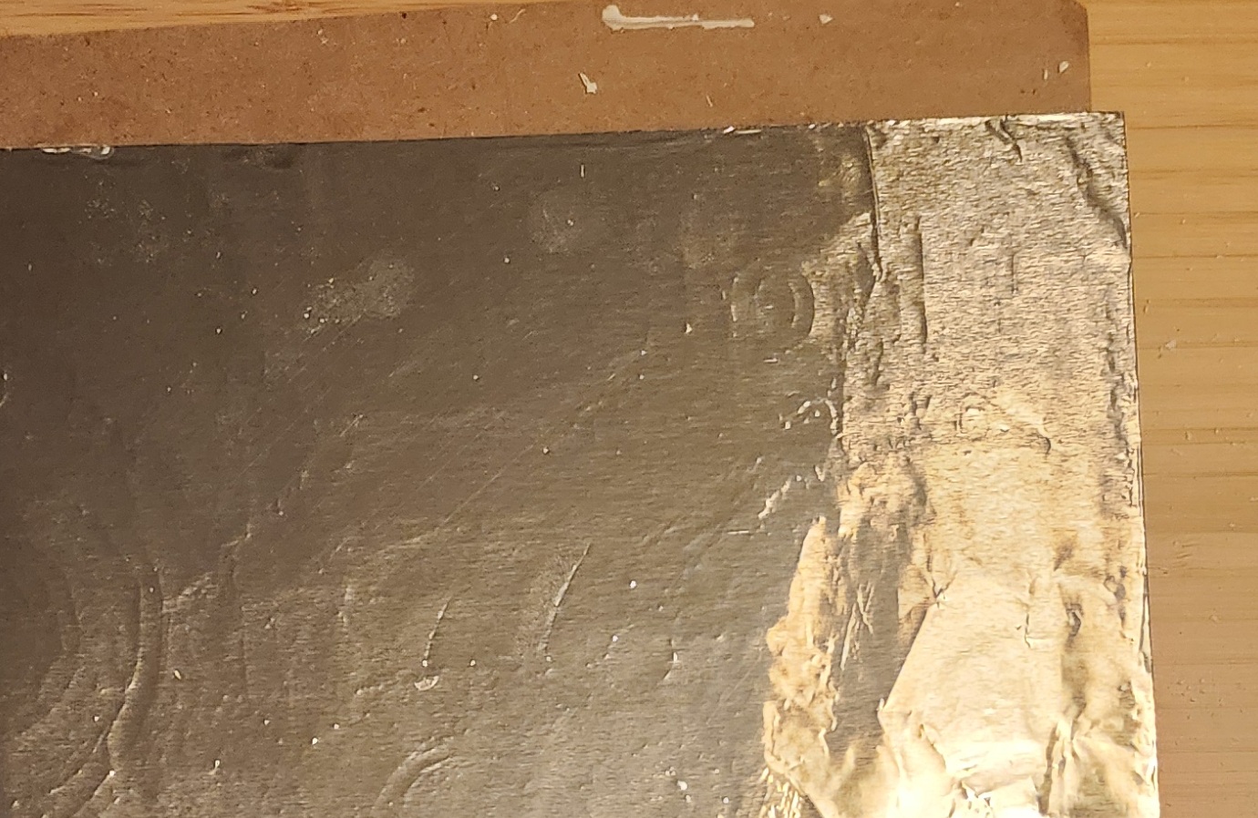 A piece covered in foil, without the grooves recessed. Outlines of the grooves can be seen nonetheless.